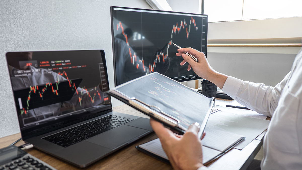 Stock exchange market concept, Business investor trading or stock brokers having a planning and analyzing with display screen and pointing on the data presented and deal on a stock exchange